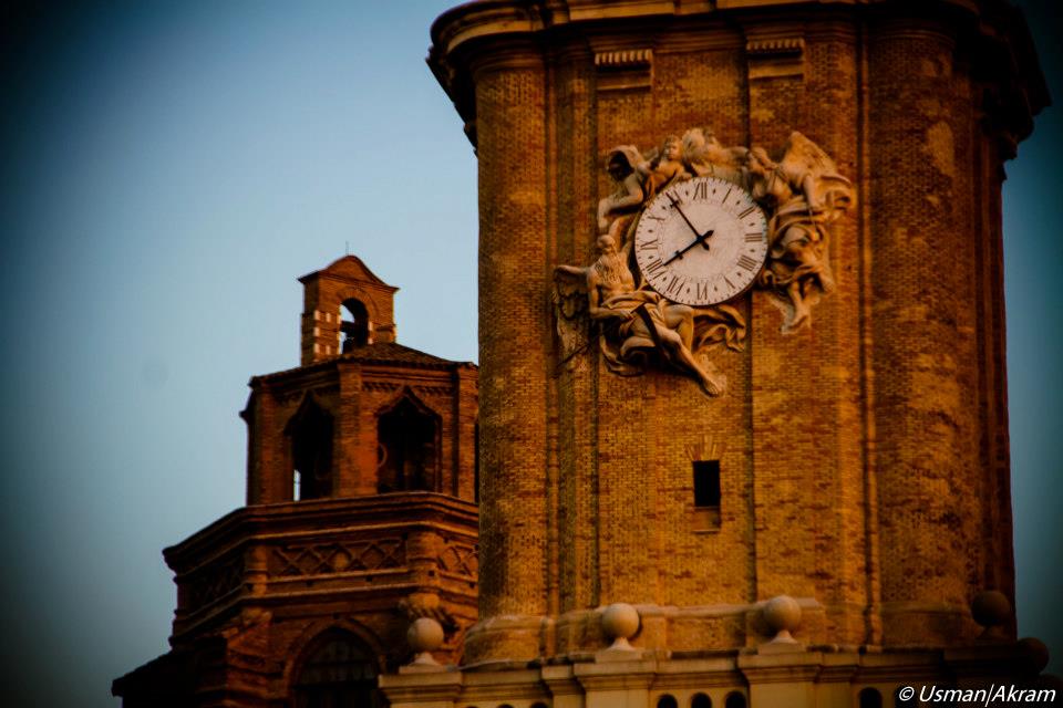 An ornate clock tower in Italy at dusk